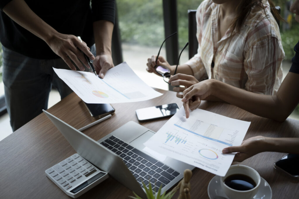 Business professionals discussing financial charts and reports during a strategy meeting, focusing on helping small businesses grow.